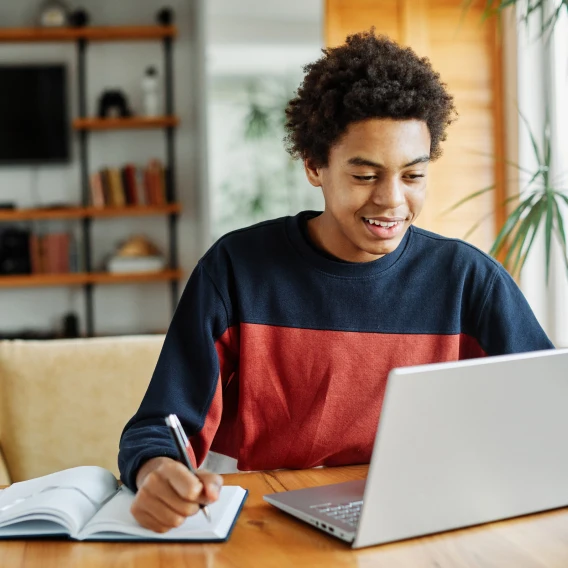 teen boy working at laptop